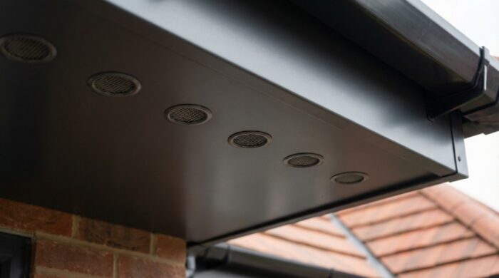 What Is a Soffit? Everything UK Homeowners and Builders Need to Know 7 Aluminium soffit board with evenly spaced circular ventilation inserts installed along the
underside of a UK house roof eave.