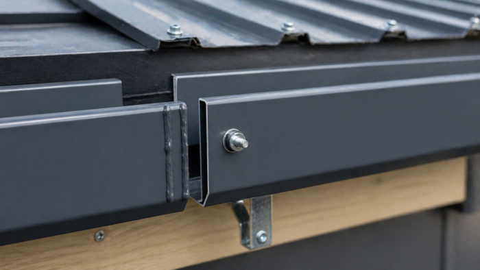 Aluminium Box Gutter: The Complete UK Guide to Sizing, Installation and Specification in 2026 5 Close-up of aluminium box gutter joint installation in anthracite RAL 7016 showing sealant bead, expansion gap, bolt fixing and fascia bracket on a UK roofline