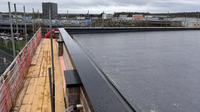 Aluminium Coping Prices: What Affects the Cost of Parapet Wall Coping 6 Aluminium coping prices for dark grey aluminium coping installed along a commercial flat roof parapet with a projecting roof-edge detail.