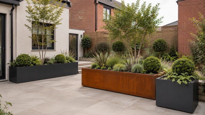Metal Planters UK: A Detailed Guide to Materials, Sizes and Outdoor Use 6 Commercial metal planters outside a contemporary UK apartment or office entrance with trees, grasses and shrubs