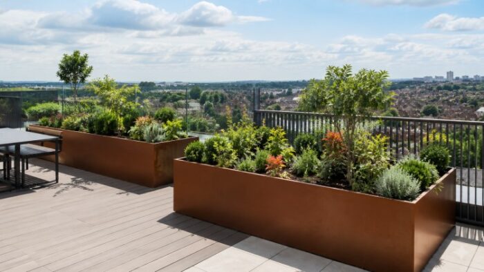 Large Metal Planters for UK Gardens and Commercial Spaces 4 Large metal planters in a corten steel rooftop garden with long rusted trough planters, mature planting and UK city views