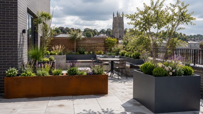 Large Metal Planters for UK Gardens and Commercial Spaces 5 Large metal planters on a UK residential terrace with corten steel trough planters, dark grey planters and structured garden seating