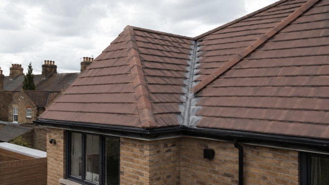 Roof Accessories: A Practical Guide for UK Roof Projects 5 Roof accessories including wall flashing, aluminium roof edge trim and black guttering on a new UK brick extension