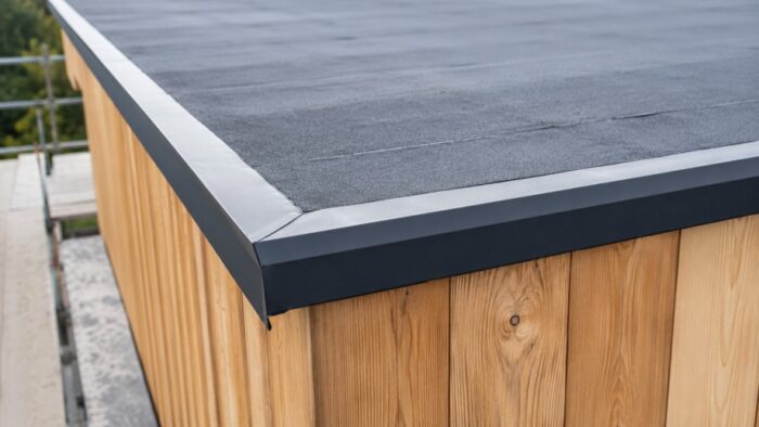 7 Essential Tips for Roof Edge Drip Trim in the UK 5 Roof edge drip trim around an external corner on a modern UK brick extension with dark aluminium trim and flat roof membrane