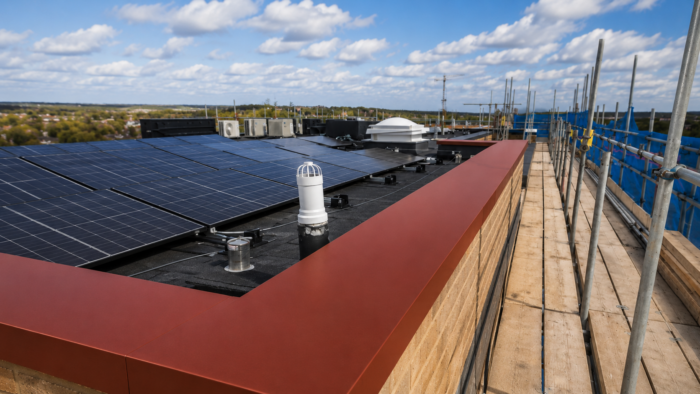 Aluminium Coping Detail: A Practical UK Guide to Wall Tops and Roof Edges 4 Feature image for Aluminium Coping Detail Guide for UK Roof Edges showing red aluminium coping and a modern city backdrop.