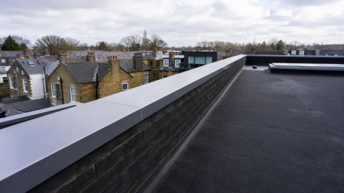 Flat Roof Aluminium Coping: 2026 UK Planning Guide 7 flat roof aluminium coping installed on a modern white building with clean roof edge detailing.