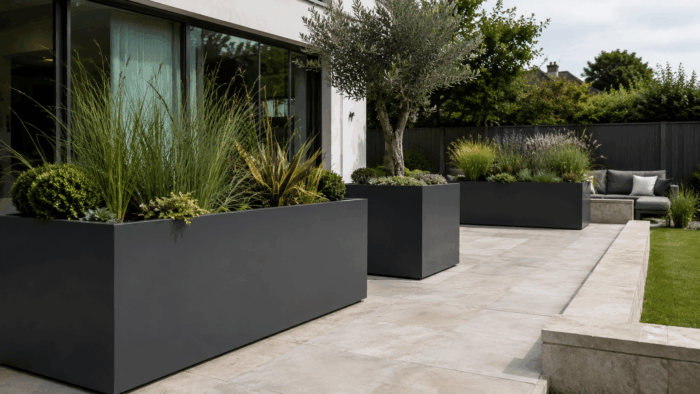 Why Large Metal Planters Need Careful Outdoor Planning 5 Large metal planters outdoor featured in a modern courtyard with structured landscaping and stylish planting design.