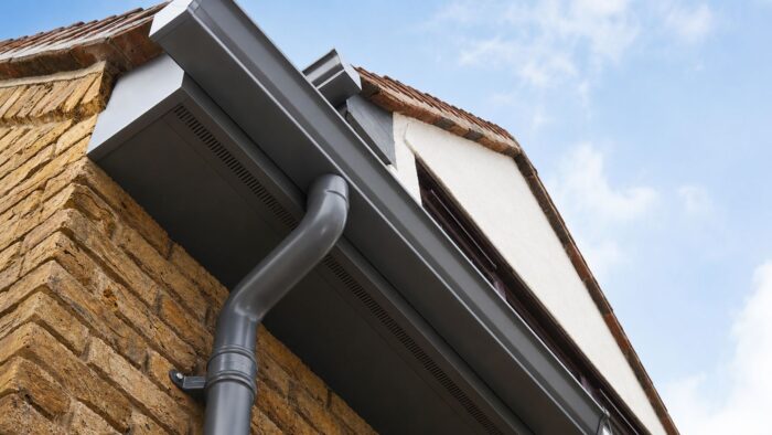 Box Guttering: What UK Projects Need to Get Right 6 Close-up view of box guttering on a brick house exterior with matching downpipe.