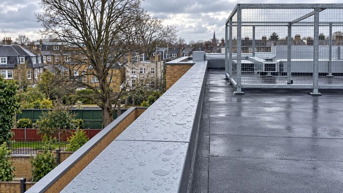 Coping Superstore for Aluminium Copings and Bespoke Projects 6 Coping superstore aluminium parapet coping with rainwater droplets on a completed UK flat roof.