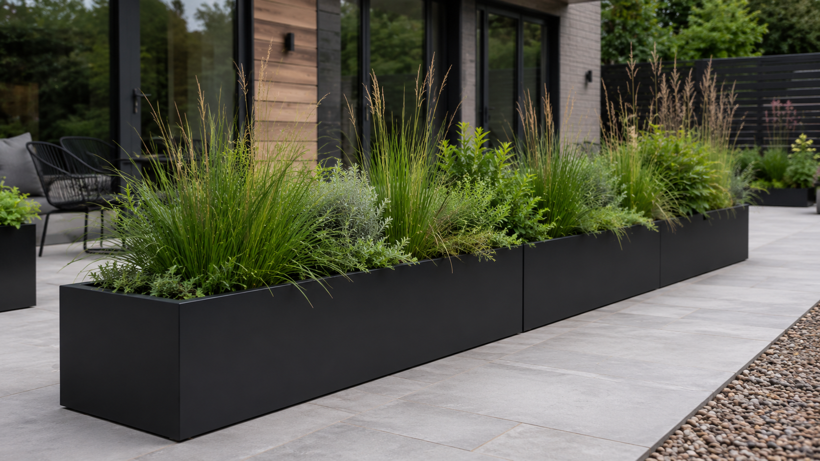 Metal outdoor planters arranged on a modern rooftop garden with clean grey finish, fresh greenery and premium outdoor landscaping.