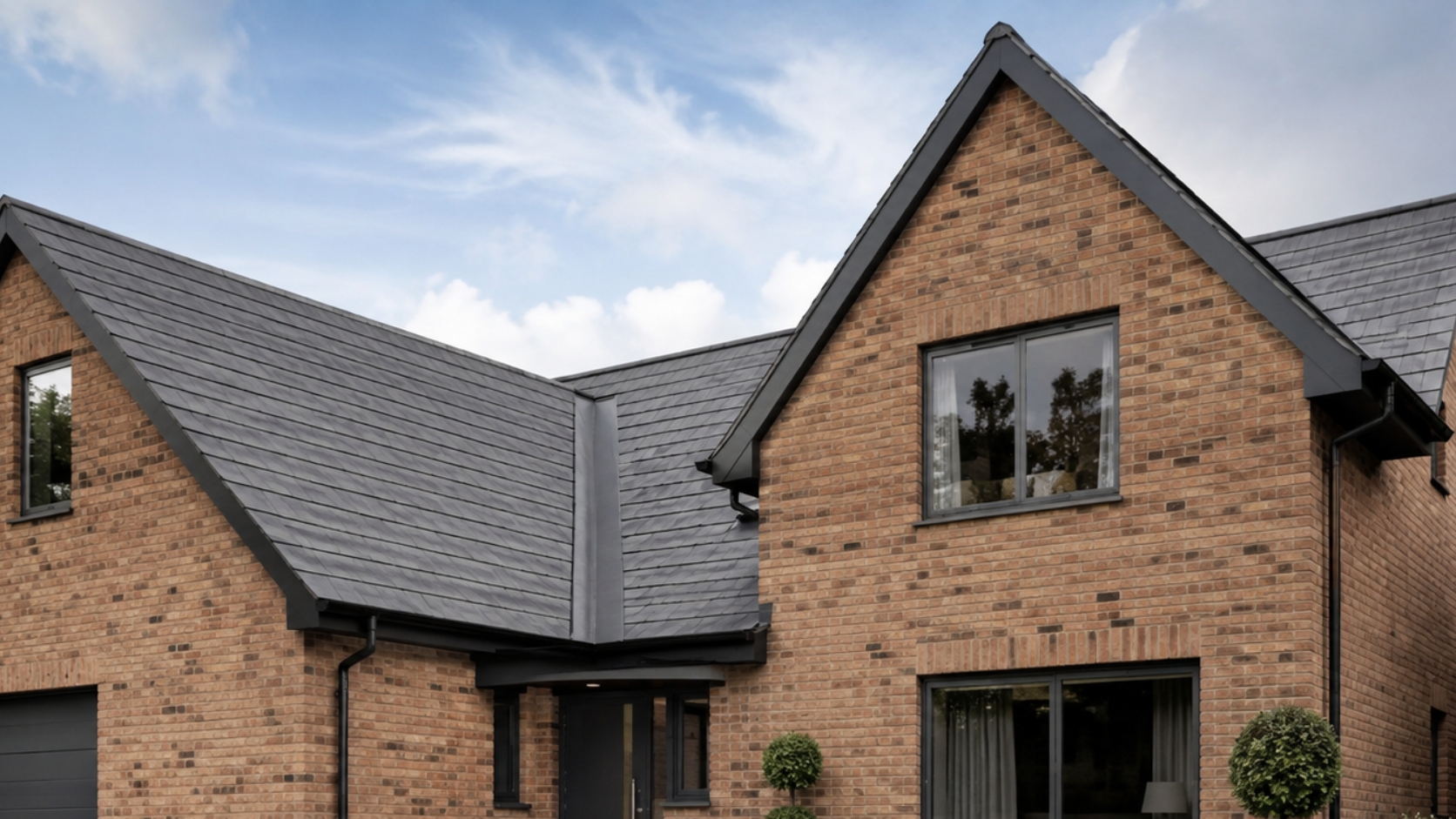 Box valley gutter detail on a UK slate roof with deep grey aluminium roofline finish.